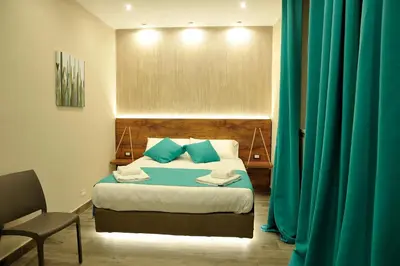 a bedroom with a bed with blue pillows and a chair at Arsenale Porto in Palermo