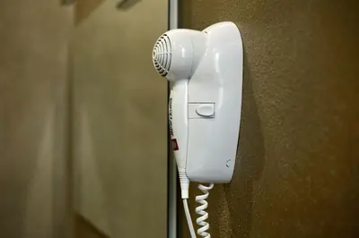 a white phone is hanging on a wall at Arsenale Porto in Palermo