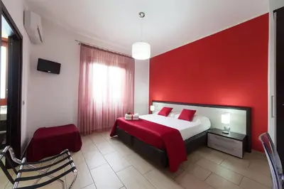 a red bedroom with a bed and a red wall at Kristal in San Vito lo Capo