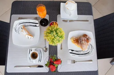 a table with plates of food and drinks and strawberries at Kristal in San Vito lo Capo