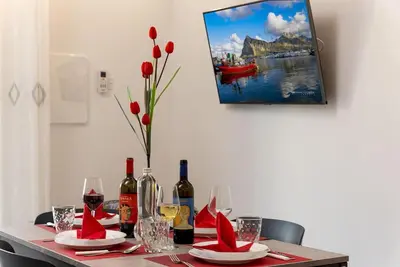 a table with wine bottles and red napkins on it at Alofara Apartment in San Vito lo Capo