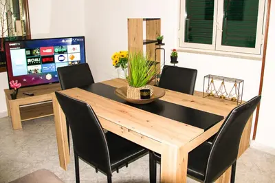 a dining room table with black chairs and a television at Gabry central apartment Palermo in Palermo