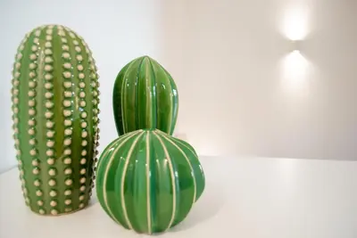 two green vases sitting next to a cactus at La casa di Nemi a San Vito in San Vito lo Capo