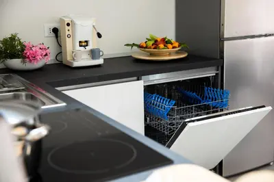 a kitchen with a dishwasher with a bowl of fruit at Appartamenti in Villa Nature con vista mare e monti in Scopello