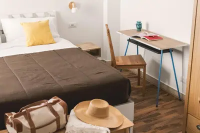 a bedroom with a bed and a table with a hat at Dante Suites in Palermo