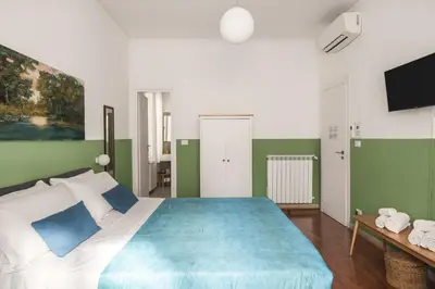 a bedroom with a large bed and a television at Dante Suites in Palermo
