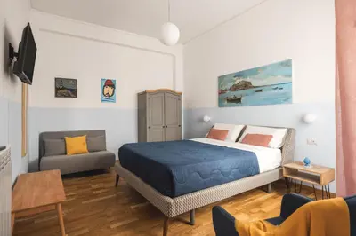 a bedroom with a bed and a desk and a table at Dante Suites in Palermo