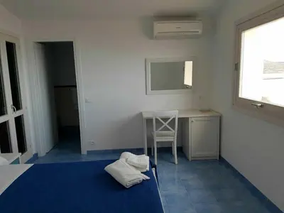 a bedroom with a bed and a desk and a chair at Le Camere della Campana in Castellammare del Golfo