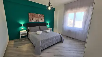 a green bedroom with a bed and a green wall at Alberira Apartments in Palermo