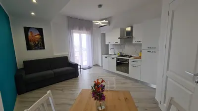 a kitchen and living room with a couch and a table at Alberira Apartments in Palermo