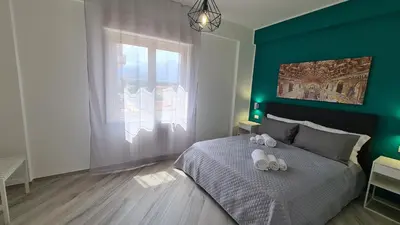 a bedroom with a bed with a green wall at Alberira Apartments in Palermo