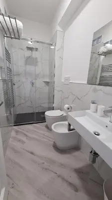 a bathroom with two sinks and a toilet and a shower at Alberira Apartments in Palermo