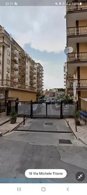 a white fence in front of some tall buildings at Alberira Apartments in Palermo