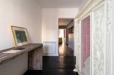 a hallway with white walls and a wooden table in a room at Celestre all'Alloro by DomuSicily in Palermo