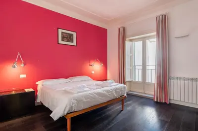 a bedroom with a red wall and a bed at Celestre all'Alloro by DomuSicily in Palermo