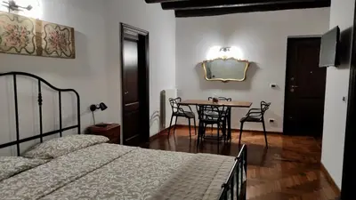 a bedroom with a table and chairs and a bed at Cathedral Sweet home in Palermo