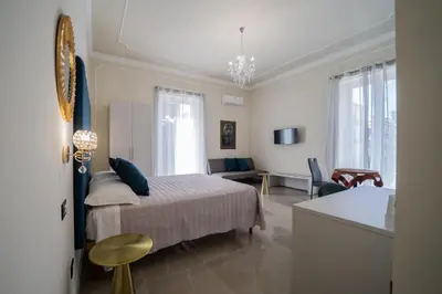 a bedroom with a bed and a living room at Amaris in Palermo