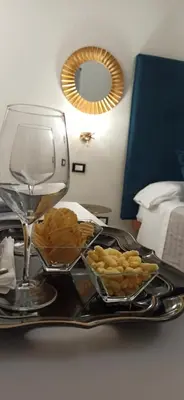 a tray with a wine glass and a plate of food at Amaris in Palermo