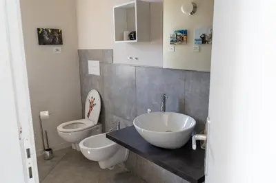a bathroom with two toilets and a sink and a toilet bowl at Click Art & Room in Trabia