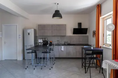 a kitchen with a table and chairs and a refrigerator at Click Art & Room in Trabia