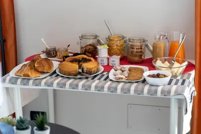 a table with bread and other food on it at Click Art & Room in Trabia