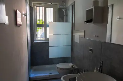 a bathroom with a toilet and a sink at Click Art & Room in Trabia