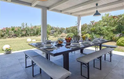a dining table and chairs on a patio at Gorgeous Home In Balestrate With Wifi in Balestrate