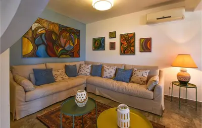 a living room with a couch and paintings on the wall at Gorgeous Home In Balestrate With Wifi in Balestrate
