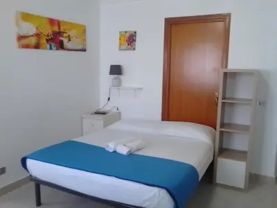 a bedroom with a bed and a wooden door at Na' zà Ciccina in Palermo