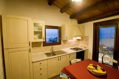a kitchen with a table with a bowl of bananas on it at Sicilia Ovest - Sea View Terrace Antiche Scale in Castellammare del Golfo