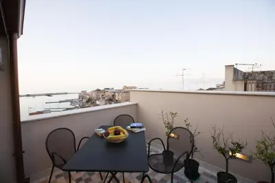a table with a bowl of fruit on a balcony at Sicilia Ovest - Sea View Terrace Antiche Scale in Castellammare del Golfo