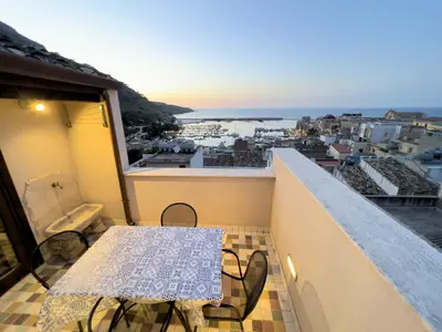 a balcony with a table and a view of a city at Sicilia Ovest - Sea View Terrace Antiche Scale in Castellammare del Golfo