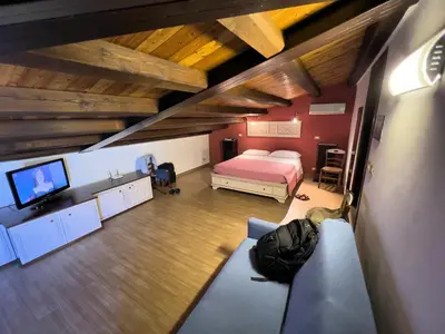 a bedroom with a bed and a tv and a couch at Sicilia Ovest - Sea View Terrace Antiche Scale in Castellammare del Golfo