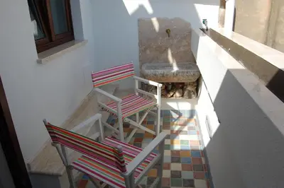 two chairs and a stone sink on a floor at Sicilia Ovest - Sea View Balcony Cerri in Castellammare del Golfo