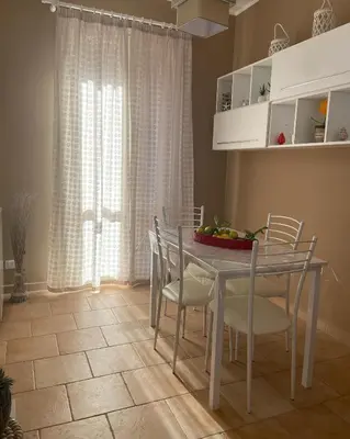 a dining room with a table and chairs and a window at L'Oasi dell'Eremita in Mondello
