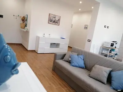 a living room with a couch and a sink at Momaliar House in Campofelice di Roccella