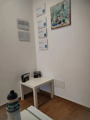 a white room with a table and a picture on the wall at Momaliar House in Campofelice di Roccella