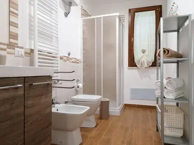 a white bathroom with a toilet and a sink at Momaliar House in Campofelice di Roccella
