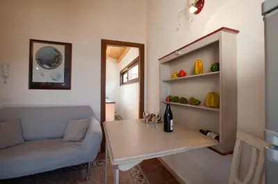 a living room with a table and a wine bottle on a shelf at Sicilia Ovest - Sea View Terrace Dolce Vita in Castellammare del Golfo