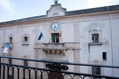 a clock on the side of a building with a balcony at Sicilia Ovest - Balcone Bellavista in Castellammare del Golfo
