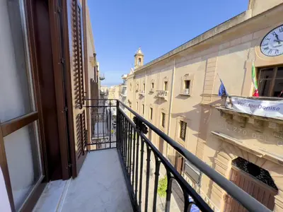 a balcony with a clock on the side of a building at Sicilia Ovest - Balcone Bellavista in Castellammare del Golfo