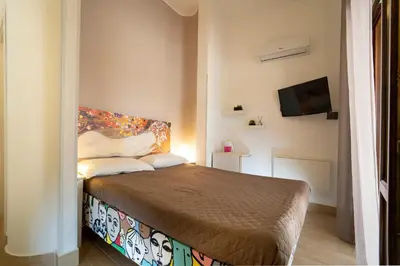 a bedroom with a bed and a flat screen tv at Kòre rooms in Castellammare del Golfo