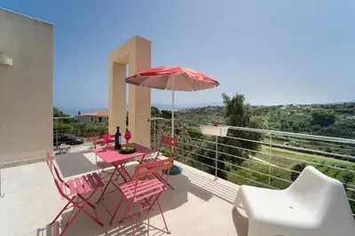 a patio with a table and chairs and an umbrella at Kòre rooms in Castellammare del Golfo