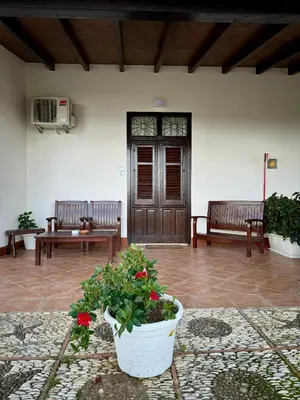 a porch with two benches and a pot of flowers at Kòre rooms in Castellammare del Golfo