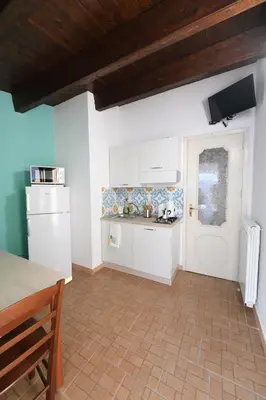 a kitchen with white appliances and a wooden ceiling at By the Sea Apartment #4 in Terrasini