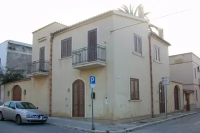 a car parked in front of a building on a street at La Palma in San Vito lo Capo