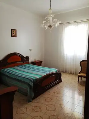 a bedroom with a bed and a chandelier at Villa Giardini in Balestrate