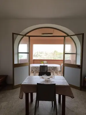 a dining room with a table and a large window at Villa Giardini in Balestrate