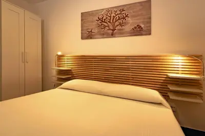 a bedroom with a bed and a wooden headboard at Design loft Marinella in Porticello in Santa Flavia