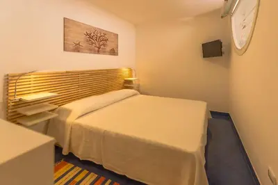 a bedroom with two beds and a clock on the wall at Design loft Marinella in Porticello in Santa Flavia